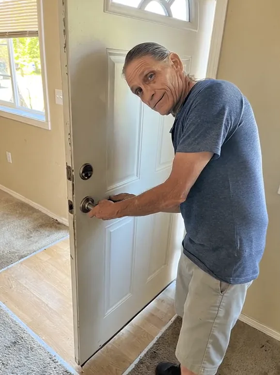 Jack Mathes working on the knob lock of a front door during a house call